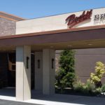 A view of the Budd's Broiler restaurant with artwork lining the side of the building.
