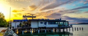 The sun sets on a stunning view of the Harbor Lights restaurant along the water-front.