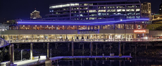 Anthony's Bell Street Diner at night with blue lights lining the exterior of the building and glowing against the waterfront.